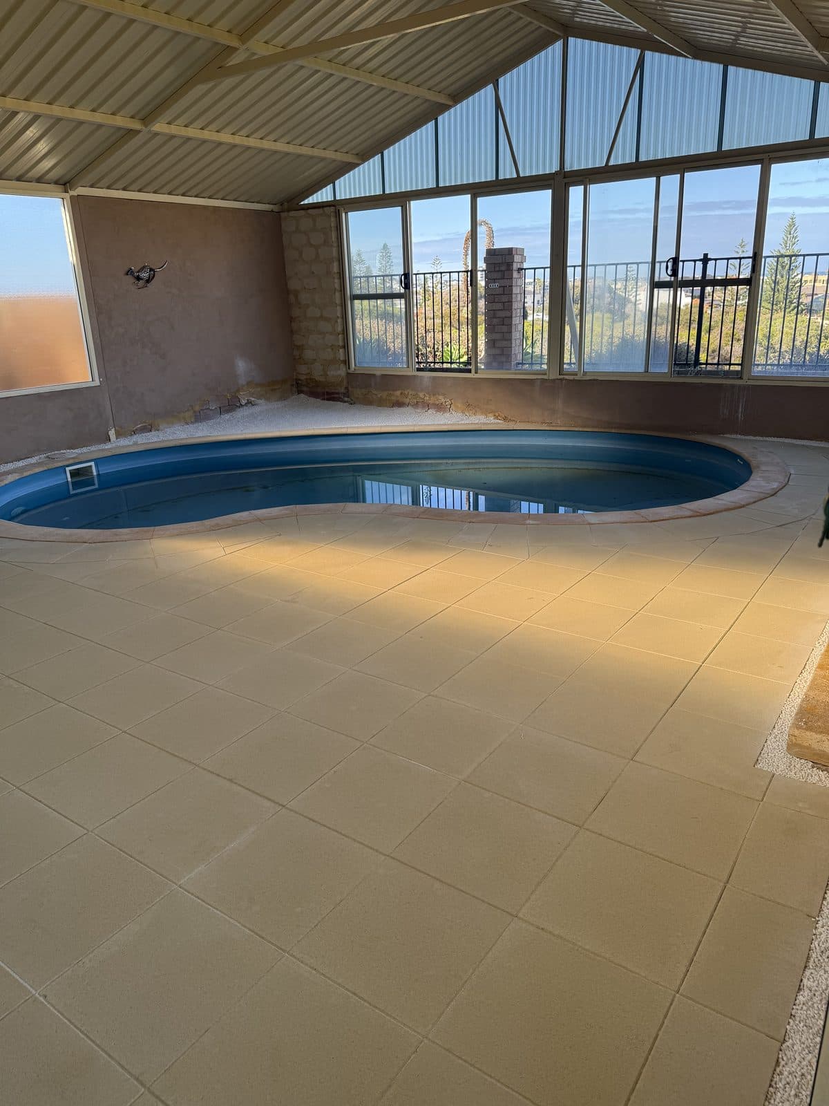 Cream paving around an indoor swimming pool, Perth