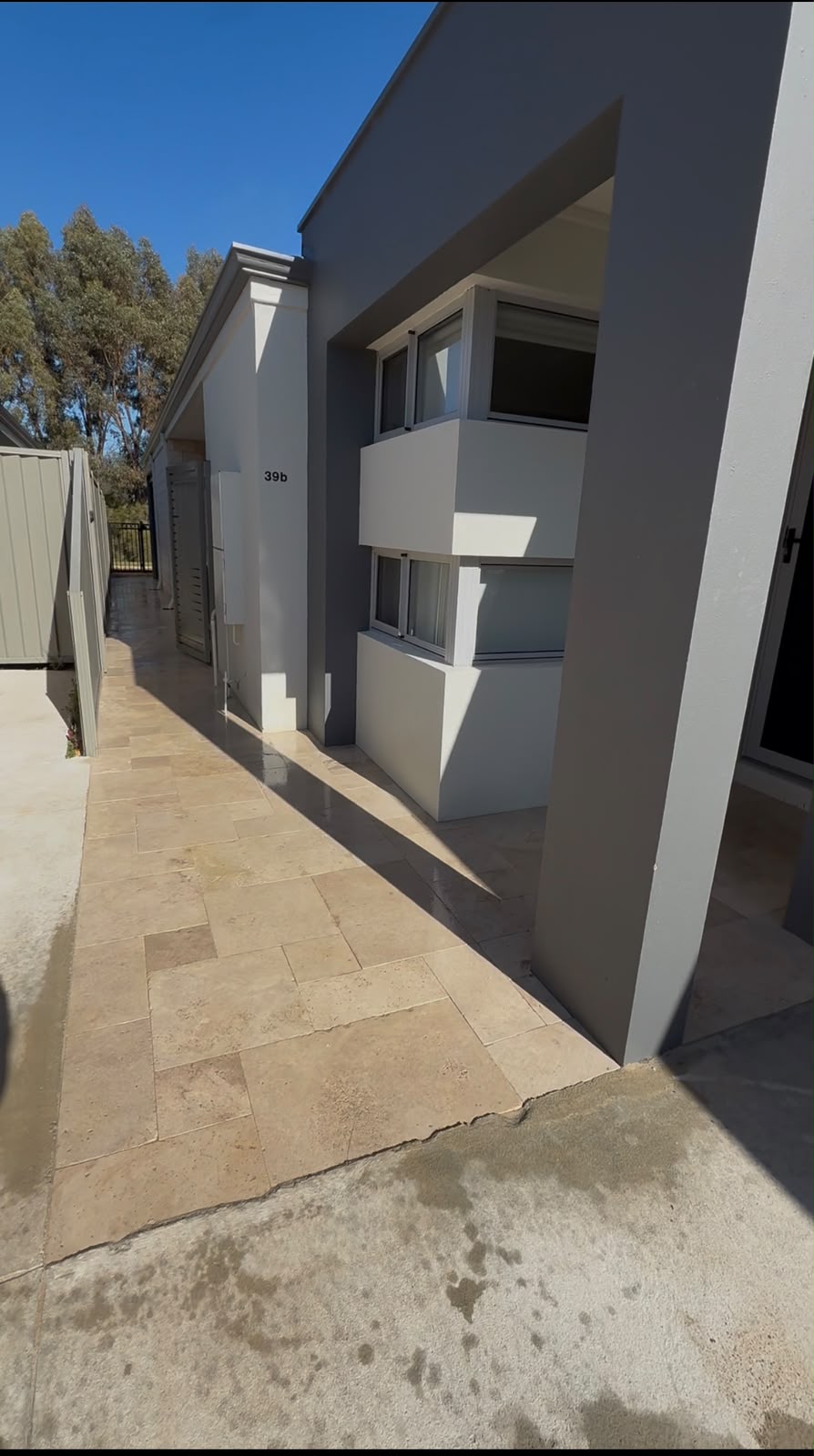 Travertine stone pavers along the side path of a Perth home