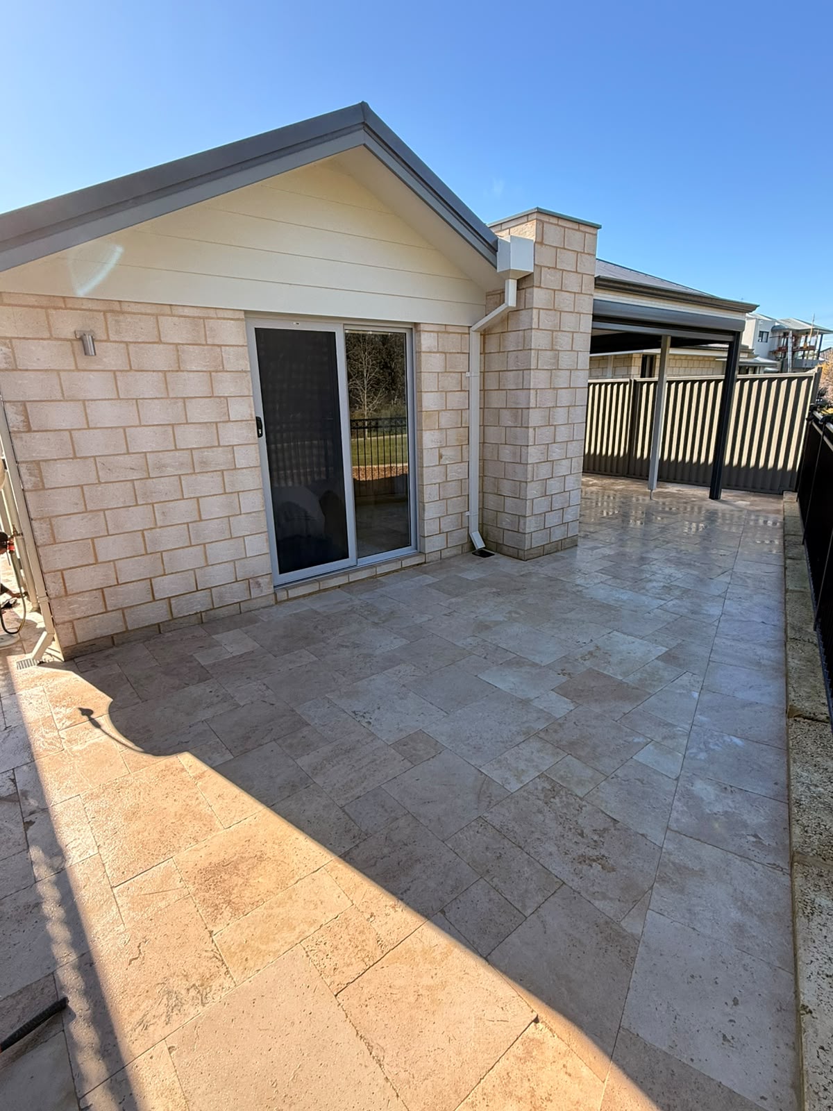 Travertine paving laid across a backyard entertaining area